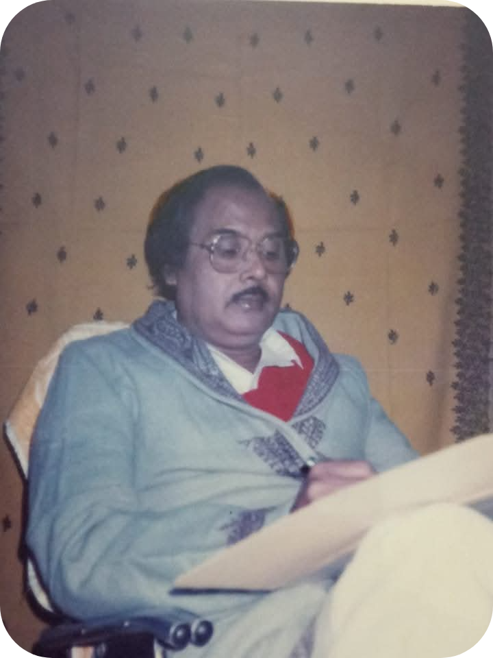 Dr. Gopesh Chandra Sarkar sitting on a chair writing